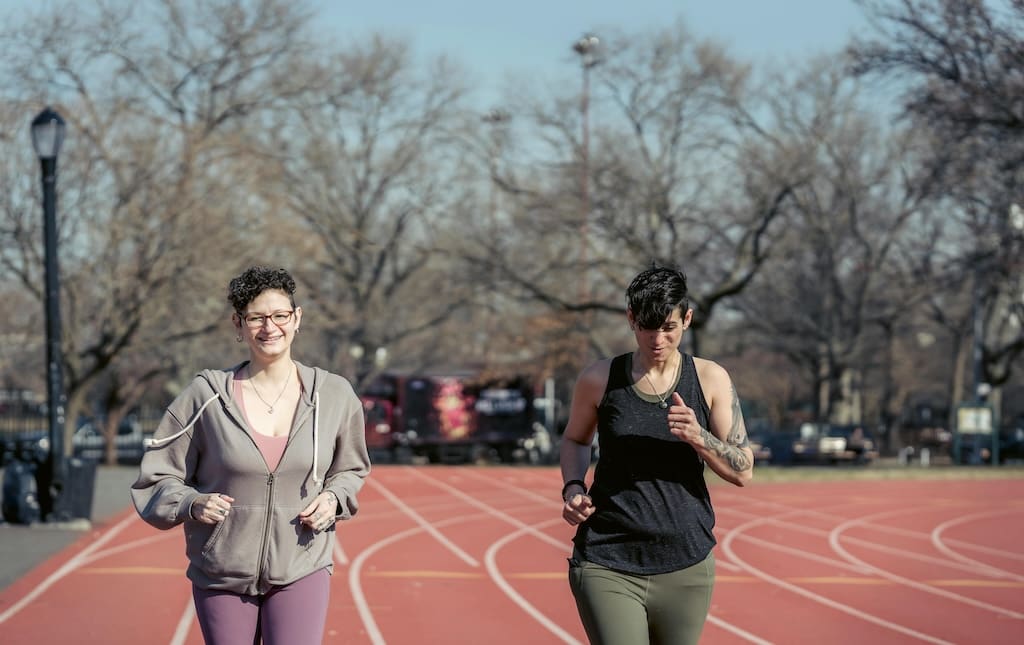 Two women running on race track