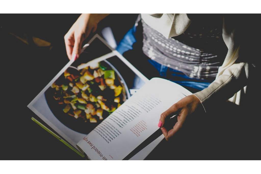 A person looking through a cookbook A person reading a cookbook