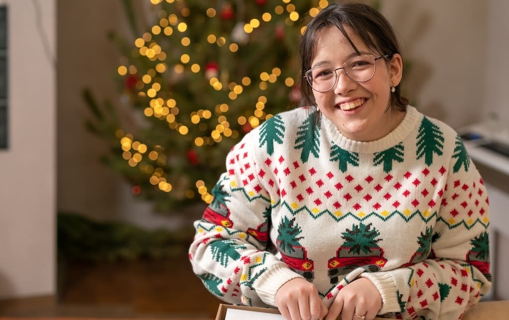 Girl smiling with ugly Christmas sweater on