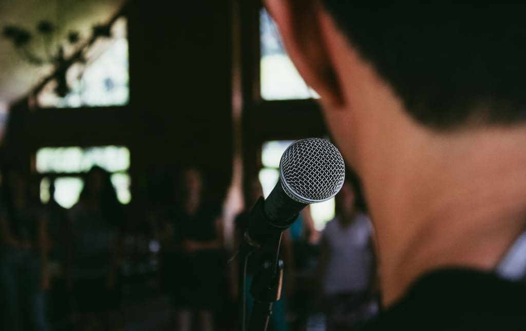 Guy standing behind a microphone