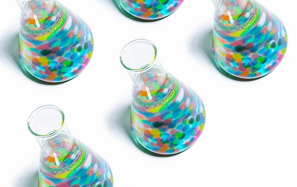 Science beakers lined up on white background