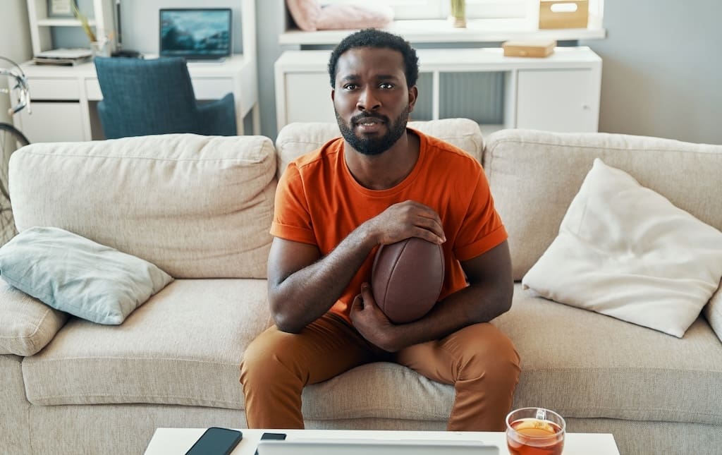 Man nervously watching football game