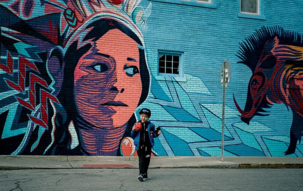 Kid geocaching by a mural
