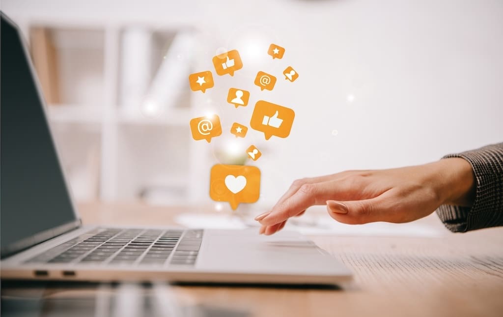 Laptop with social media icons floating out of it