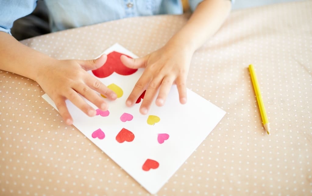 Kids handing making a Valentine's Day card