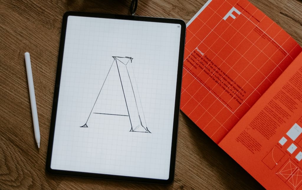 Drawing tablet and pen lying on floor next to an instruction book