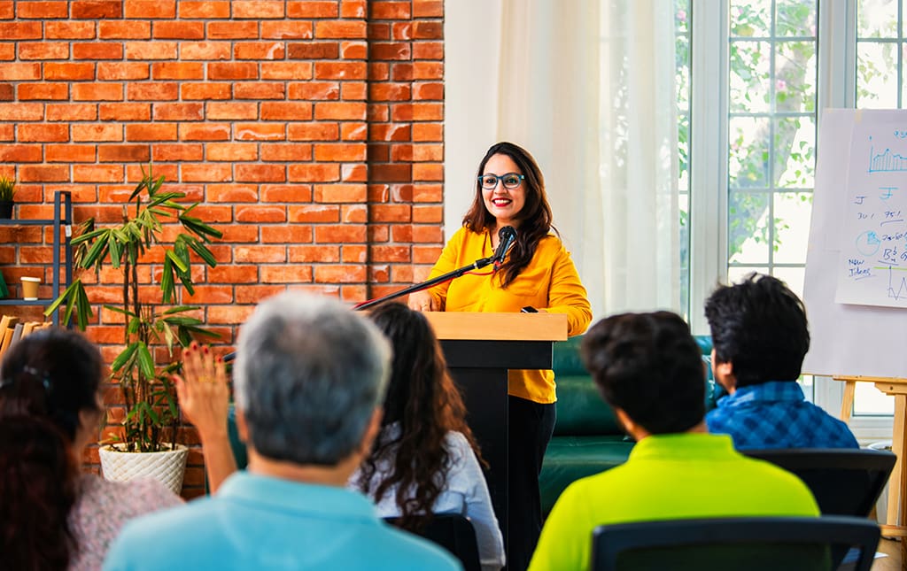 A woman gives a talk at a school alumni event
