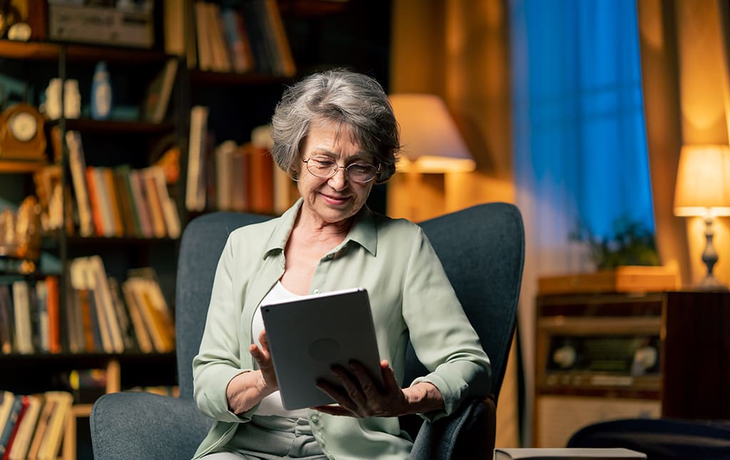 A senior reads a high school alumni newsletter on a tablet