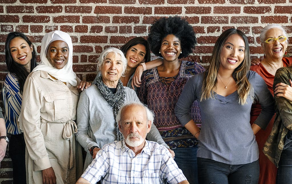 Group of diverse people standing in front of a brick wall