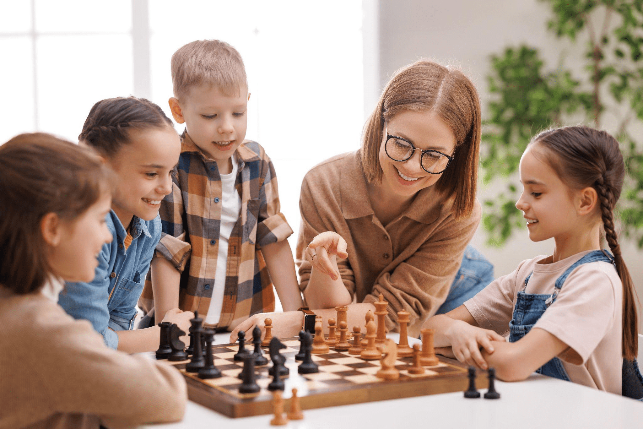 Children and teacher playing chess